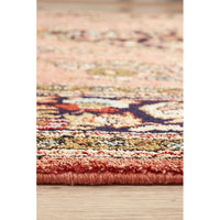 Close-up of a multicolored patterned hand knotted Persian silk rug on a wooden floor.