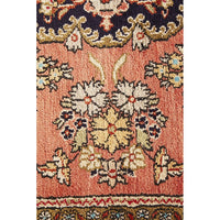 Close-up of a patterned hand knotted Persian silk rug with intricate designs.