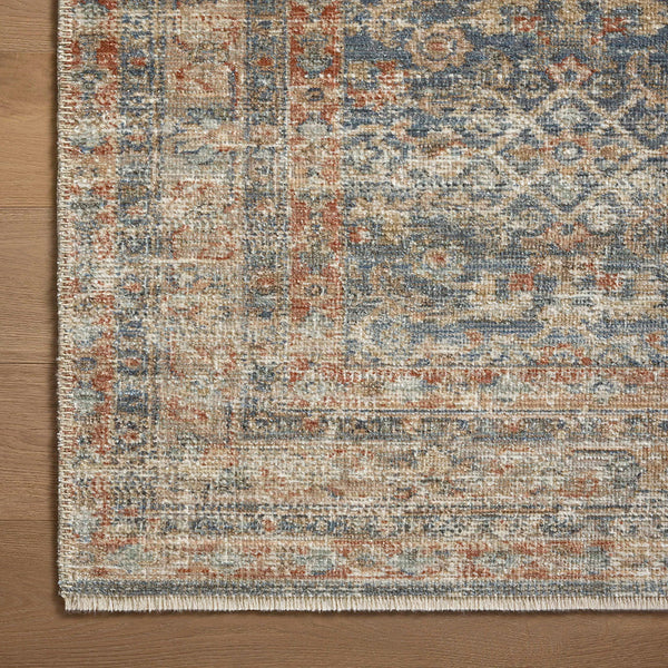 Blue earth-toned transitional rug with multi-colored textured geometric pattern and distressed finish.