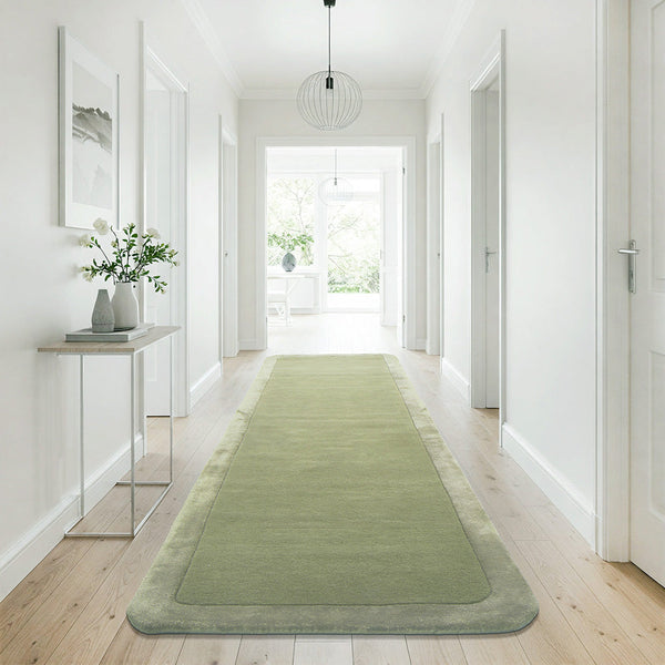 Green wool viscose modern runner rug with curved border in bright hallway setting.