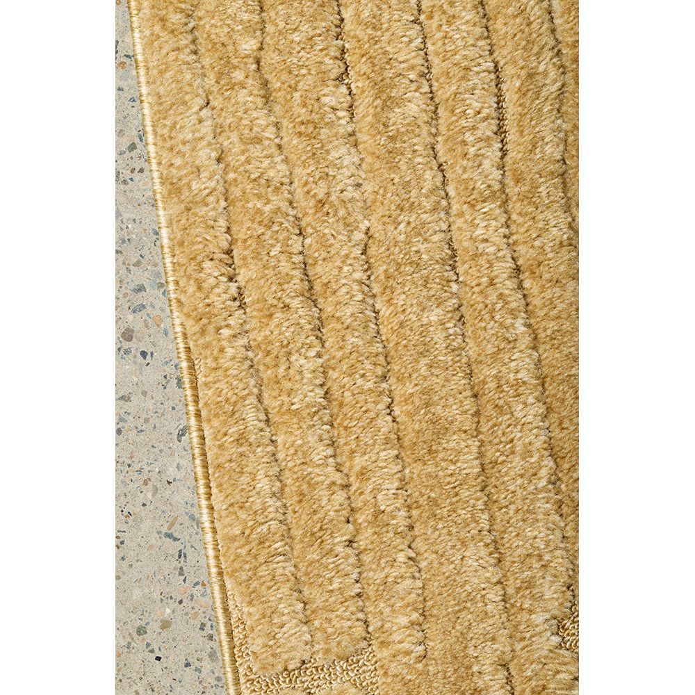 Gold textured rug on a concrete floor