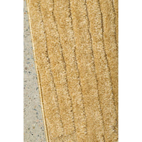 Gold textured rug on a concrete floor