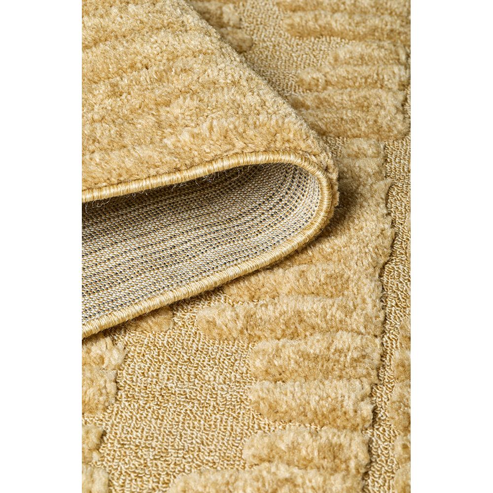 Close-up of a textured gold coloured  rug with a focus on the edge.
