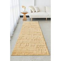 Gold textured runner rug in a living room setting with a white sofa and small table.