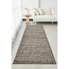 Long rectangular brown textured rug on a light gray floor in a living room setting.