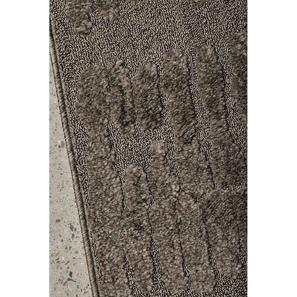 Textured brown runner rug on a concrete surface