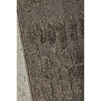 Textured brown runner rug on a concrete surface