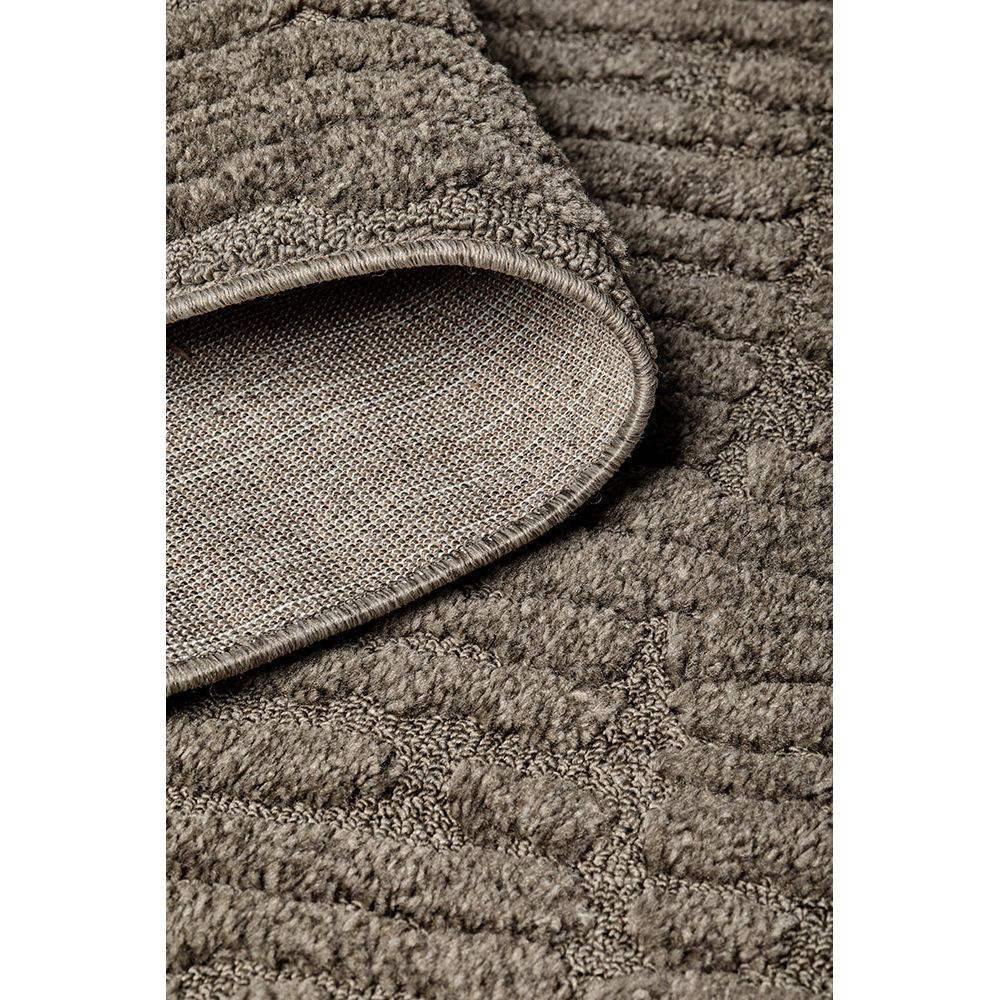 Close-up of a textured brown rug with a folded corner.