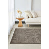Living room with a textured gray rug, white sofa, and wooden side table.