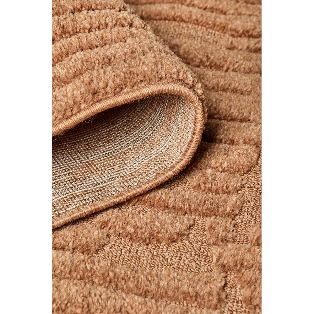 Close-up of a rust coloured textured rug corner