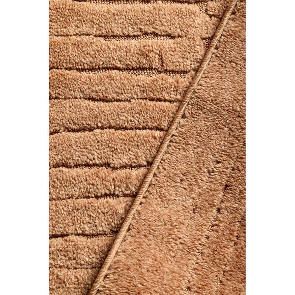 Rust-colored modern rug with raised geometric textured pile and diagonal line detail.