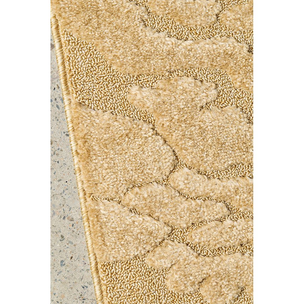 Close-up of a textured gold rug on a concrete floor