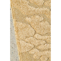 Close-up of a textured gold rug on a concrete floor