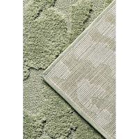 Close-up of a textured green rug with a geometric pattern