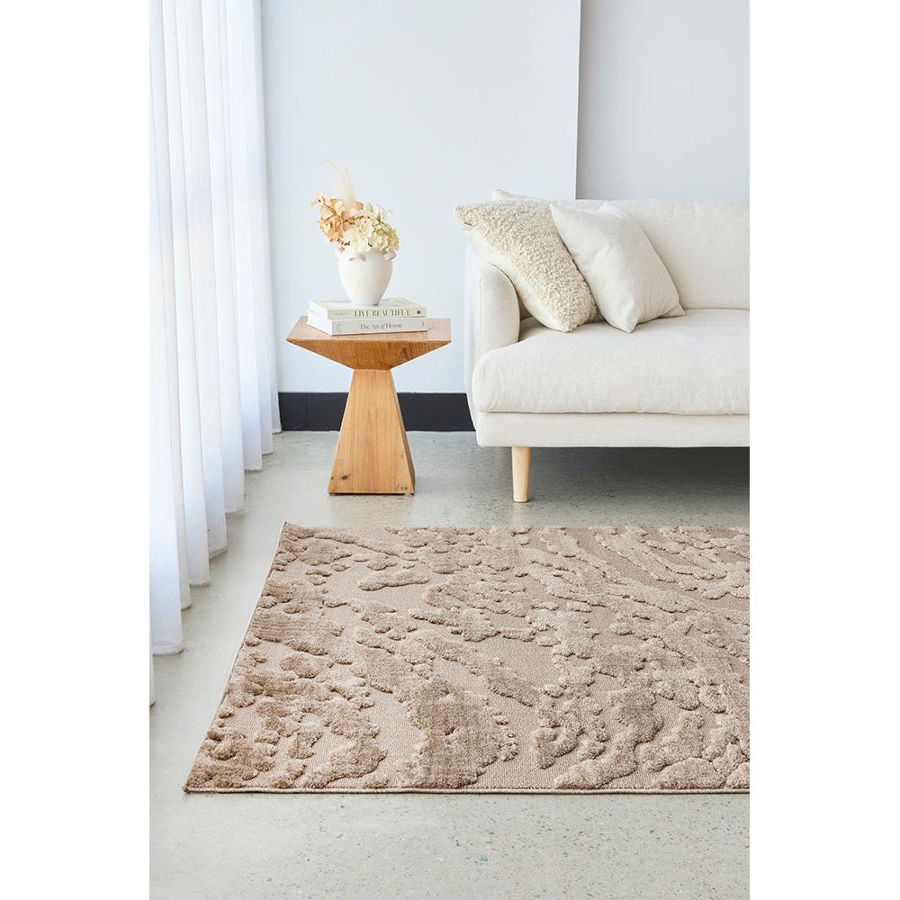 Living room with a beige textured rug, white sofa, and wooden side table.