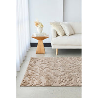 Living room with a beige textured rug, white sofa, and wooden side table.