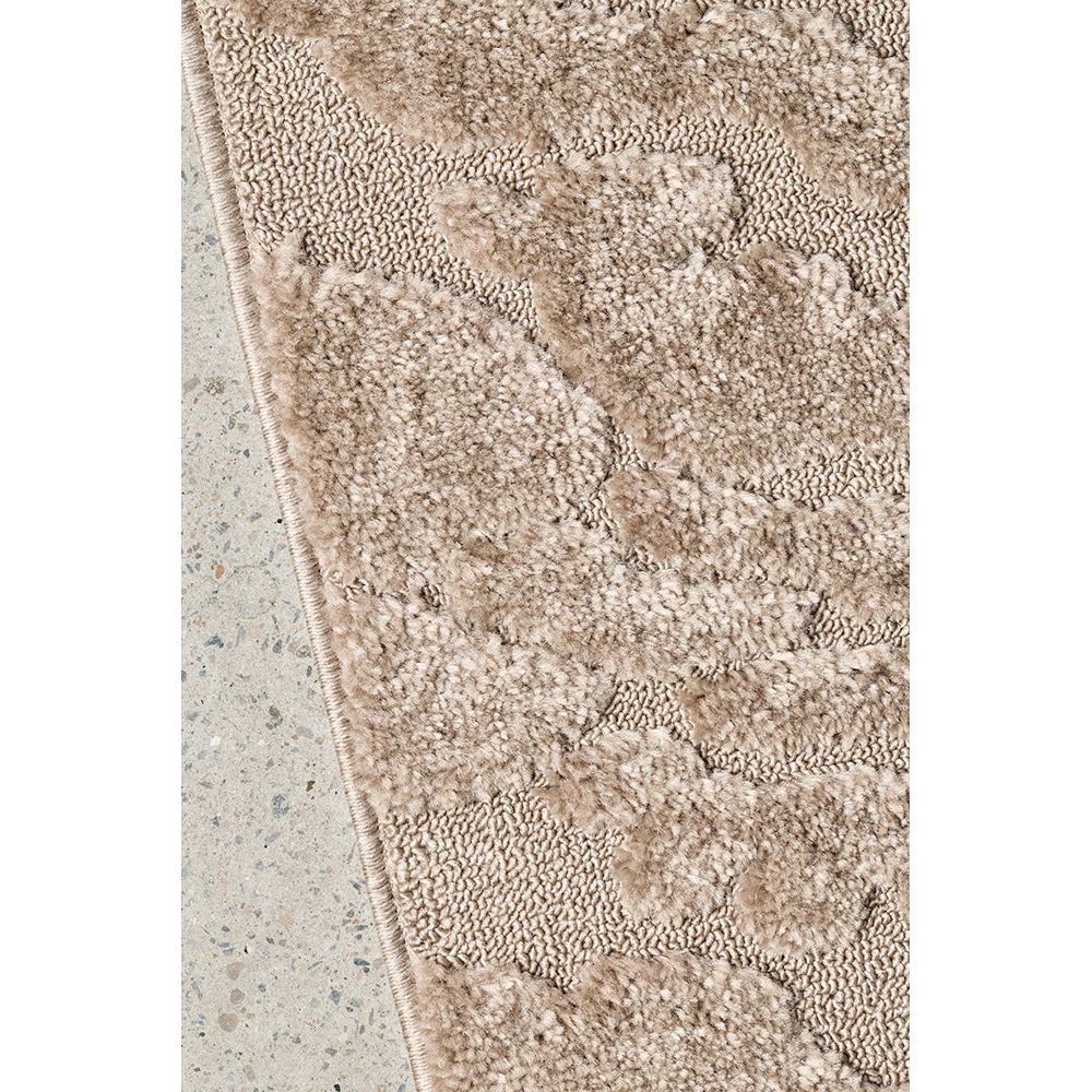 Textured beige rug on a concrete floor