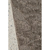 Textured brown rug on a concrete floor