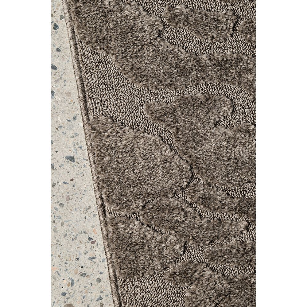 Textured brown rug on a concrete floor