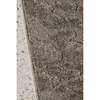 Textured brown rug on a concrete floor