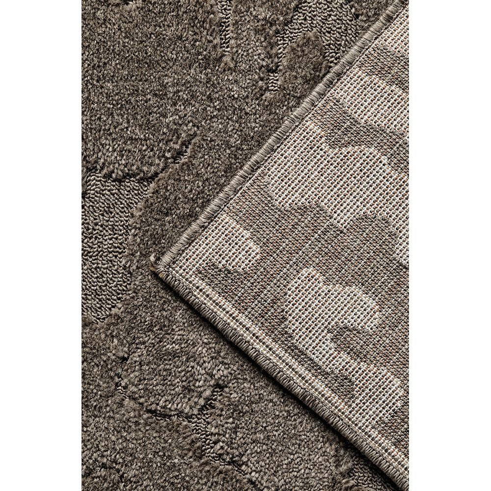Close-up of a textured rug corner with a geometric pattern