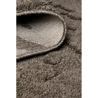 Close-up of a textured brown rug with a woven border.