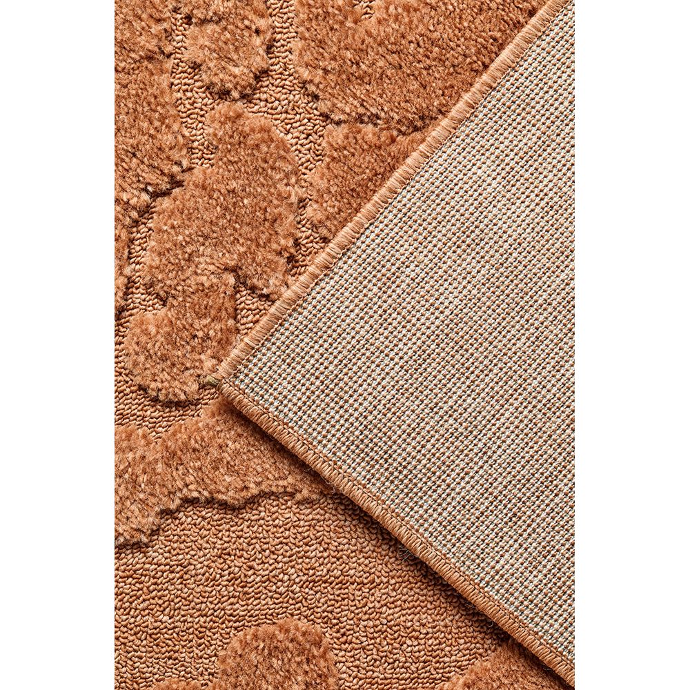 Close-up of a rust coloured rug with a corner overlap.
