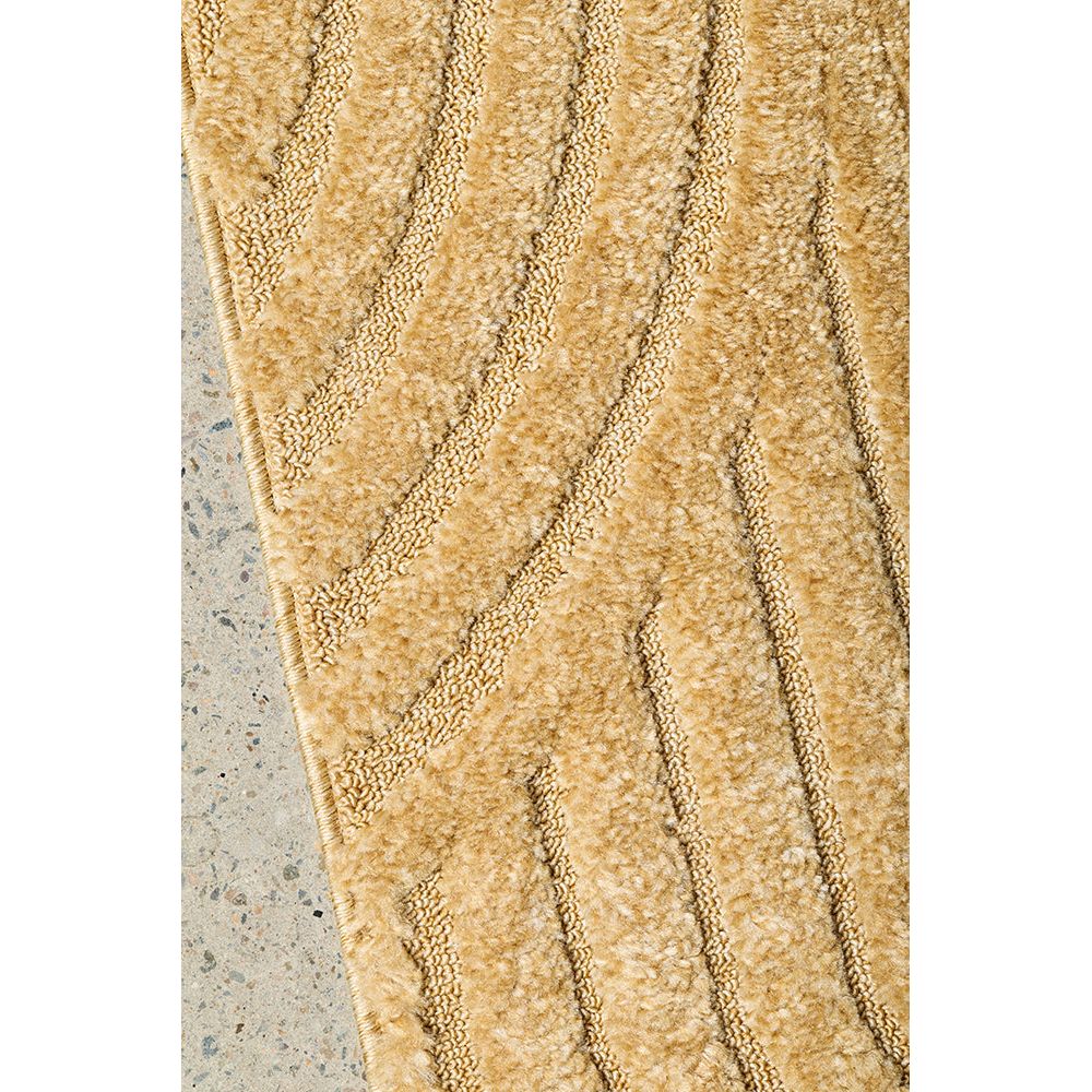 Textured gold coloured rug on a concrete floor