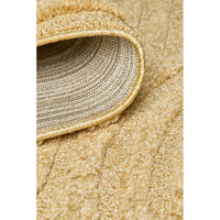 Close-up of a gold coloured textured rug with a focus on the edge.