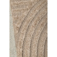 Close-up of a textured beige runner rug border on a light gray background