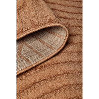 Close-up of a rust coloured textured rug with a checkered pattern