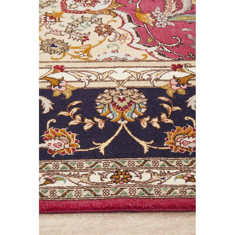 Close-up of a patterned Persian rug with intricate designs on a wooden floor.