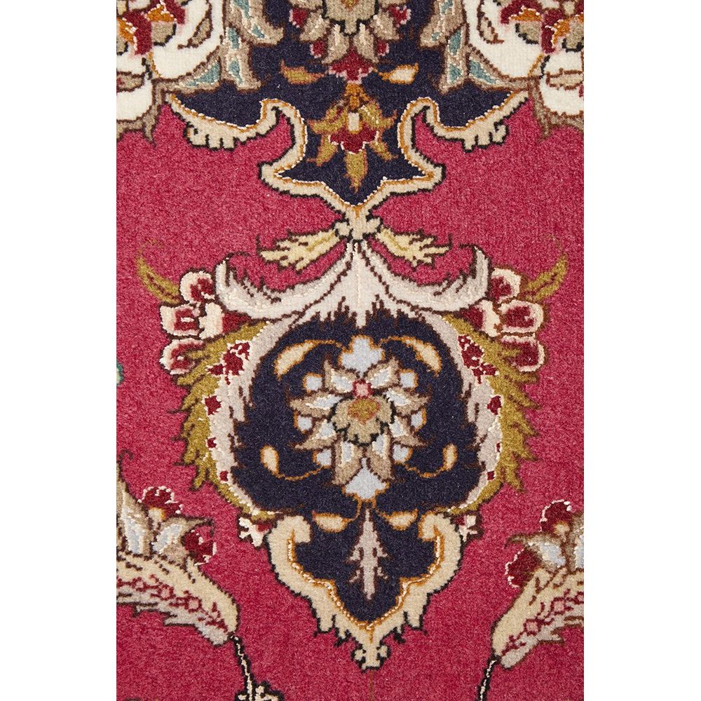 Close-up of a patterned Persian wool rug with intricate designs on a red background