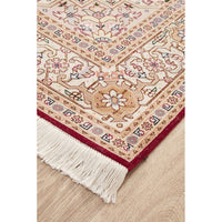 Close-up of a patterned Persian wool rug with tassels on a wooden floor