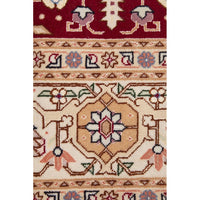 Close-up of a patterned Persian wool rug with geometric and floral designs.