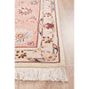 Decorative Persian wool rug with floral patterns and white fringe on a wooden floor.