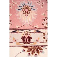 Close-up of a pink floral patterned Persian wool rug with intricate designs.