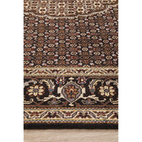 Close-up of a patterned Persian wool rug with intricate designs on a wooden floor.