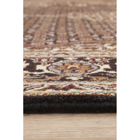 Close-up of a patterned Persian wool rug with a wooden floor background