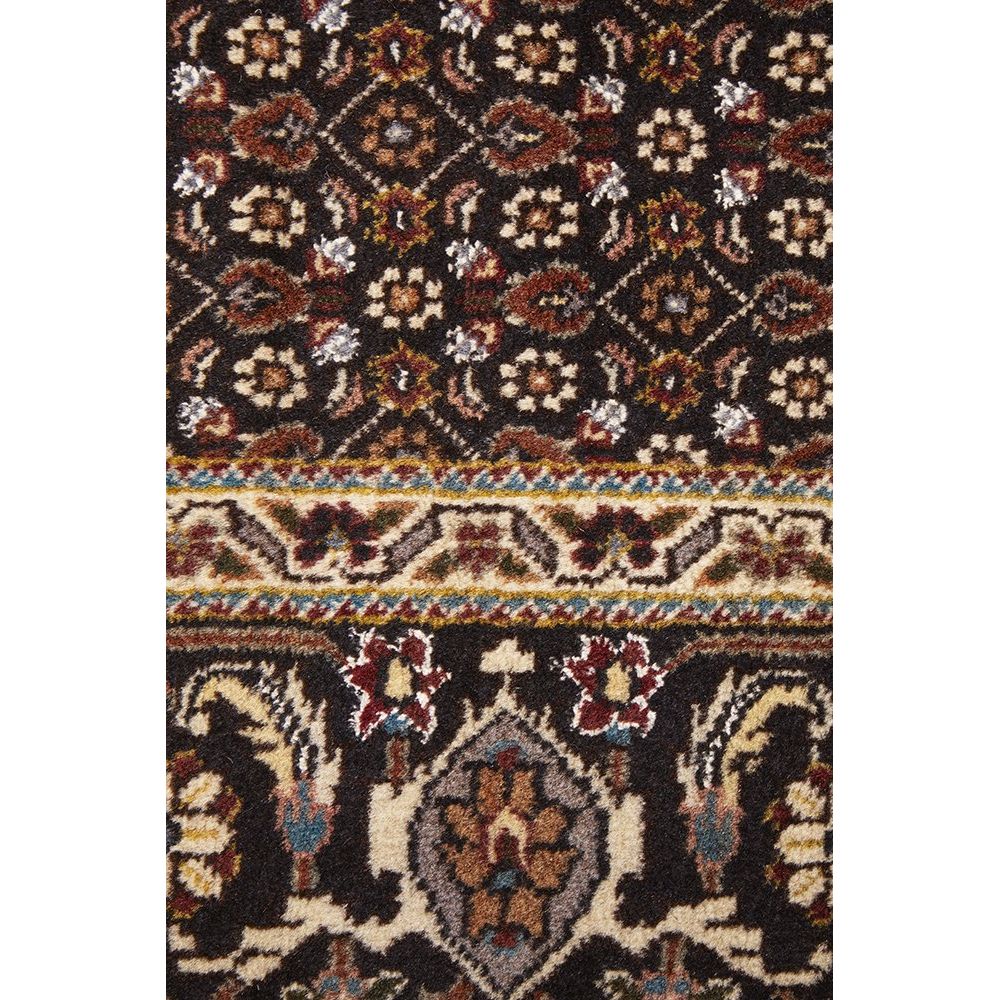 Close-up of a patterned Persian wool rug with intricate designs.