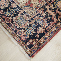Decorative Persian wool rug with intricate patterns on a light wooden floor