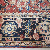 Close-up of an intricately designed Persian wool rug with floral and geometric patterns.