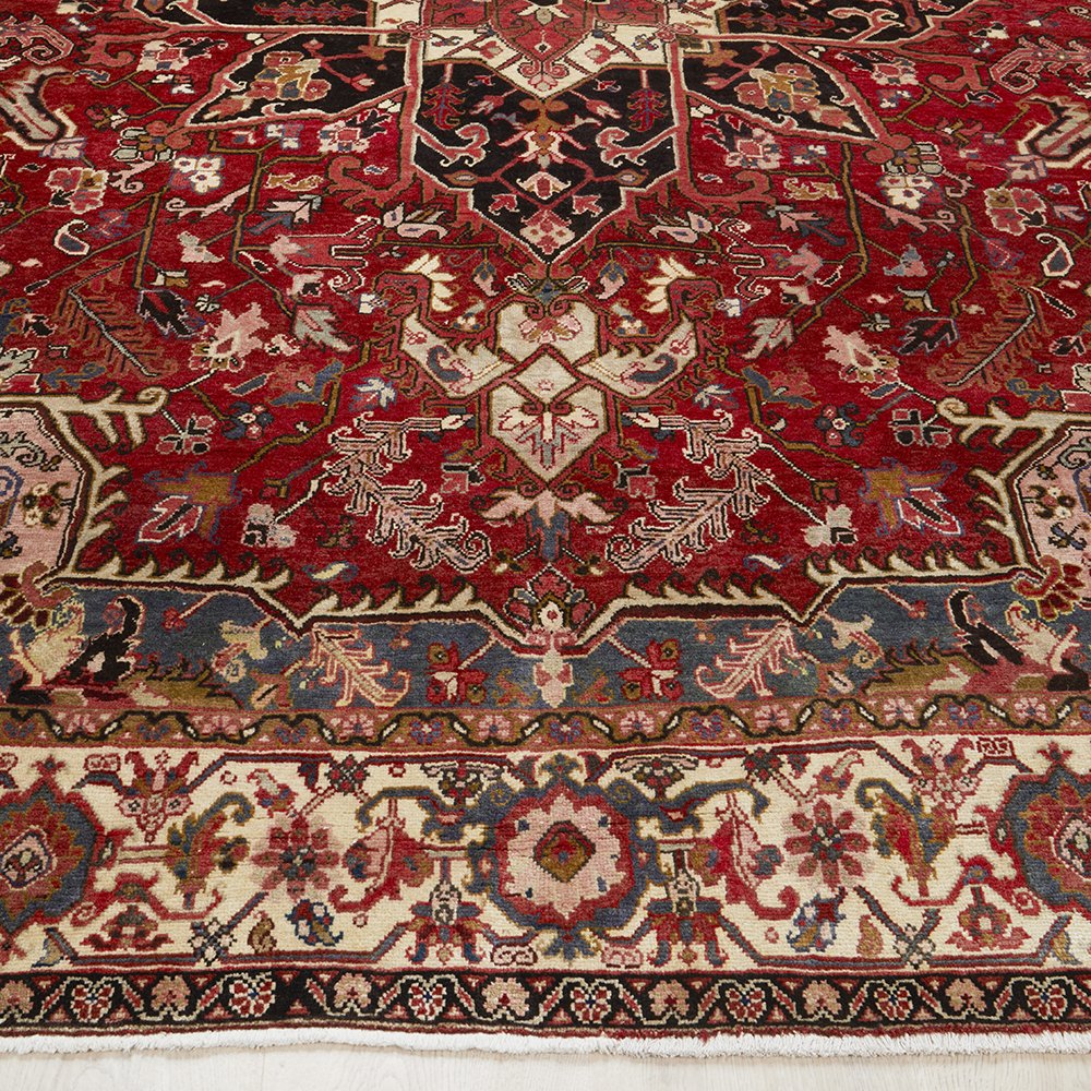 Close-up of an intricately designed Persian wool rug with red, grey, and beige colours.