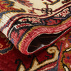 Close-up of a rolled-up traditional Persian wool rug with intricate patterns.