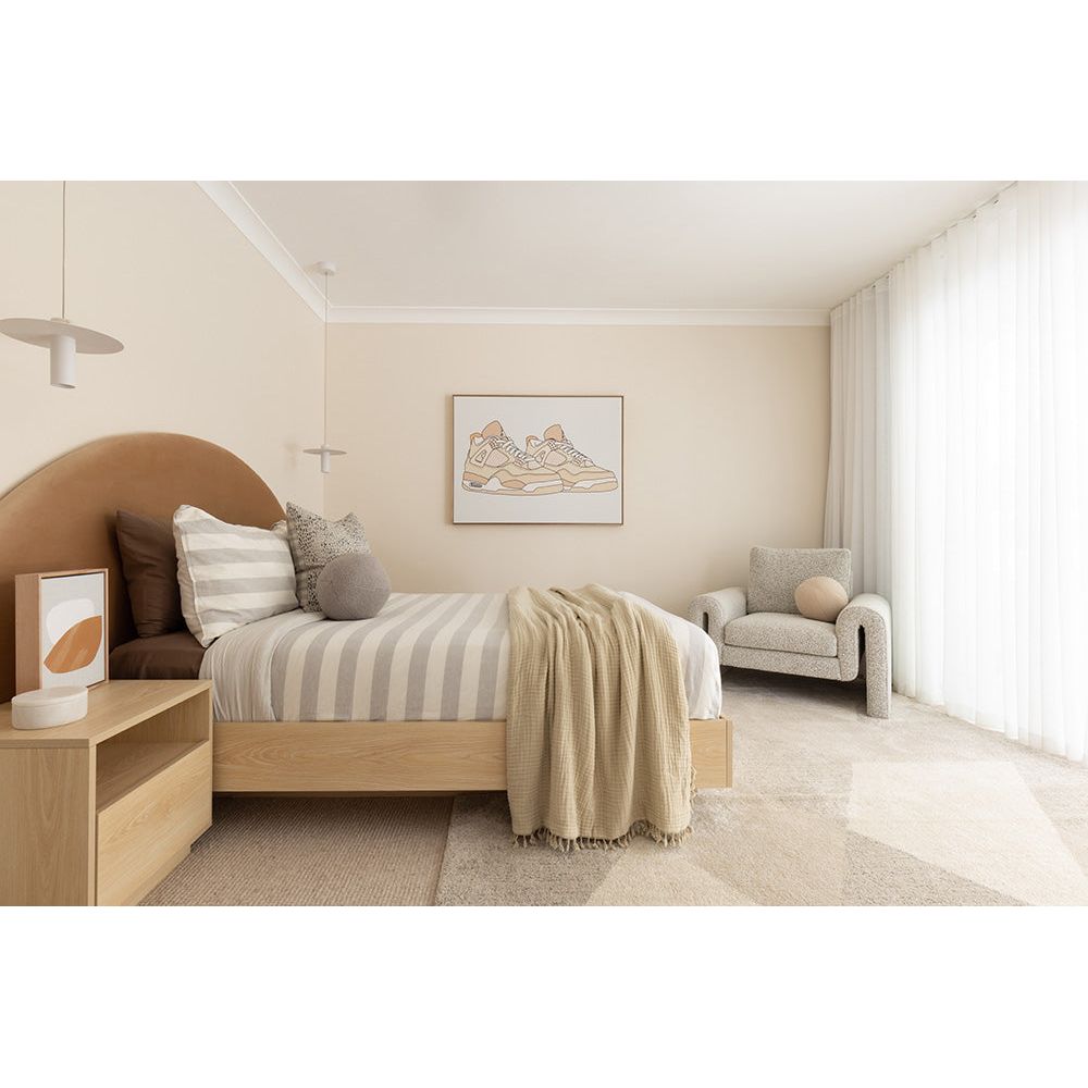 Modern bedroom with a bed, nightstands, and a chair.