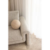 Gray textured sofa with a round beige pillow against a neutral background