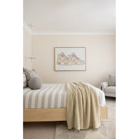 Modern bedroom with a bed, striped bedding, and a framed picture on the wall.