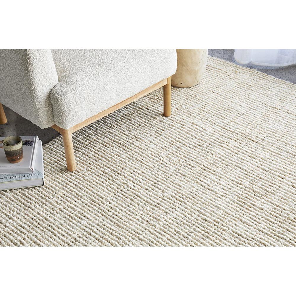 Beige carpet with a wooden chair and a small table in the corner.