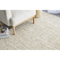 Beige carpet with a wooden chair and a small table in the corner.