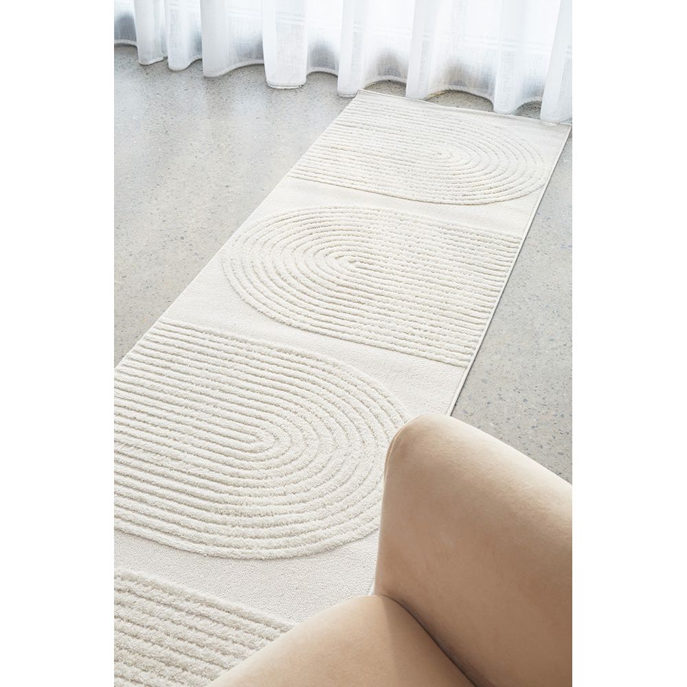 White modern runner rug with concentric circle and linear patterns on smooth floor.